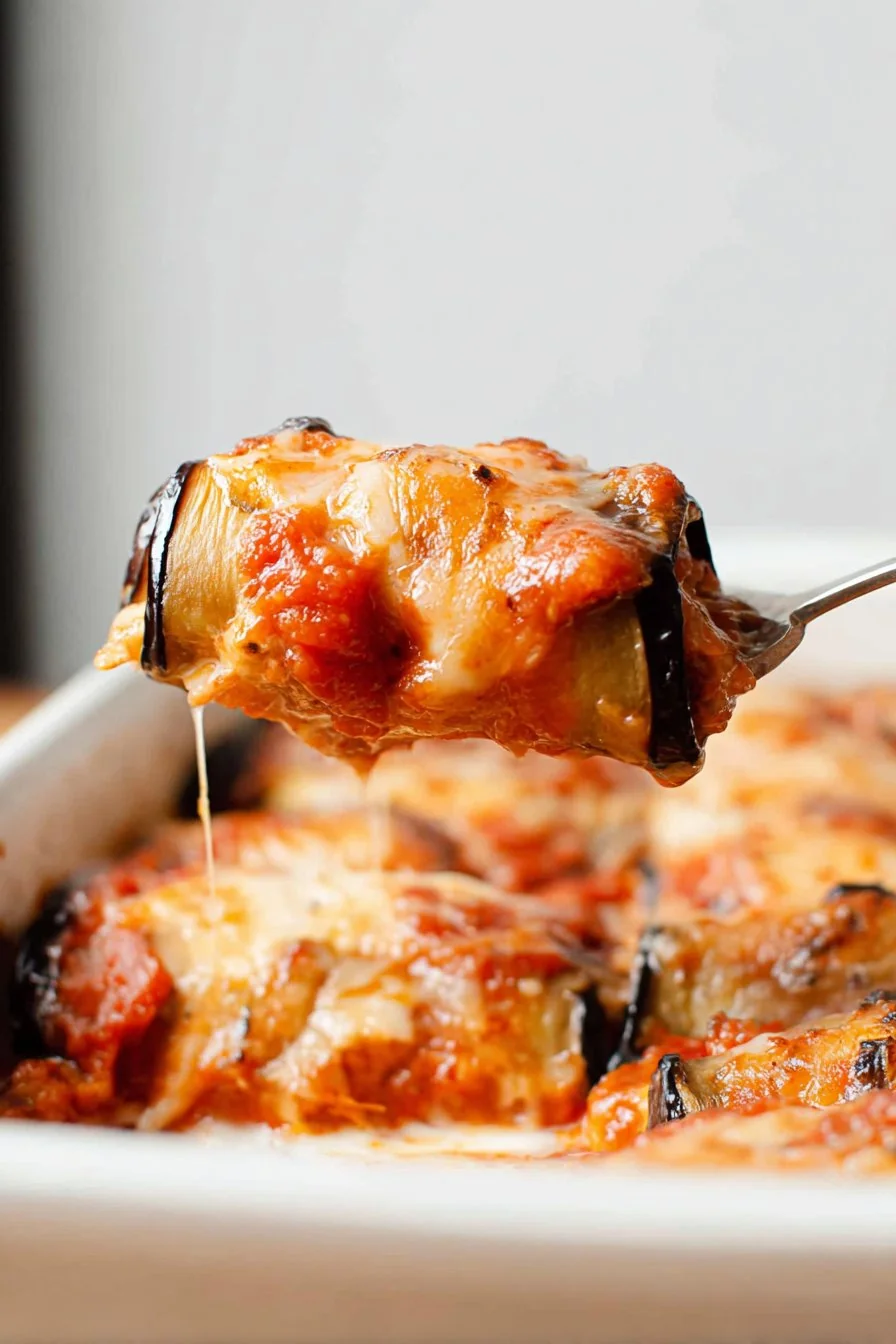 Golden-baked Eggplant Rollatini in a white casserole dish
